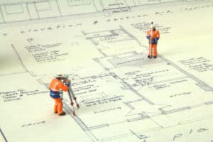 This image displays figures who are performing the necessary tasks to complete a land survey.