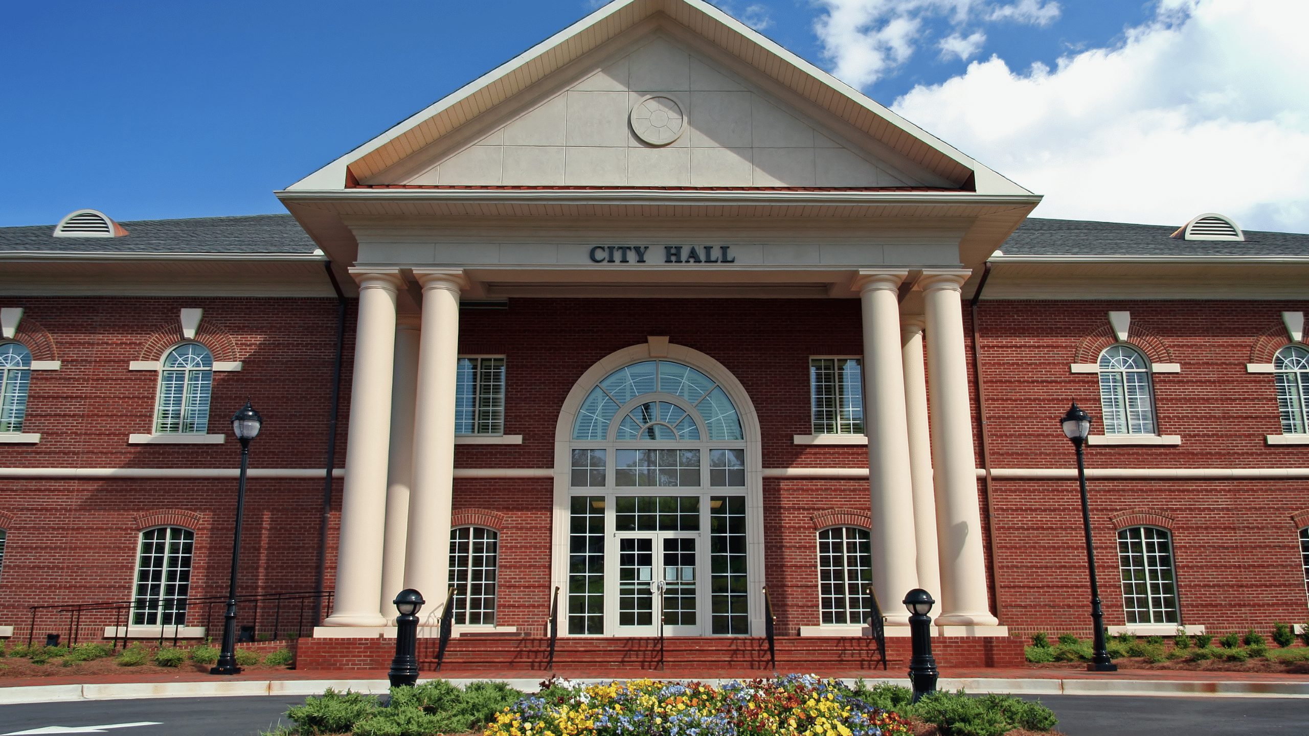 Front entrance of a municipal city hall building representing local government leadership and community administration