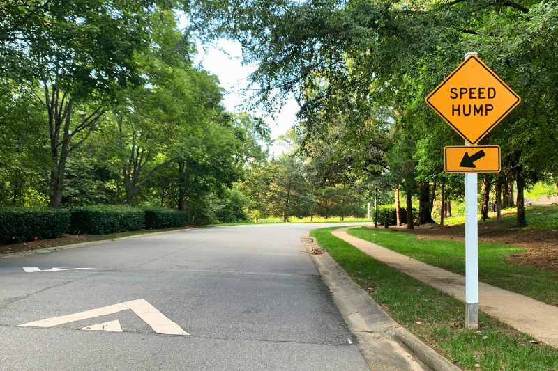 Traffic calming speed hump and traffic control sign